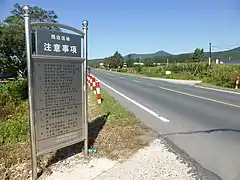 国道302号線脇に立つ見学の注意事項