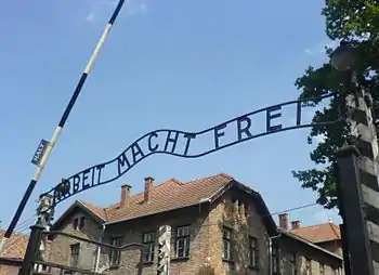 「ARBEIT MACHT FREI（働けば自由になる）」と記された、第一強制収容所の門のアーチ。「B」のプレートのみ明らかに上下逆に付けられているが、その理由は不明である。一説には、設置作業にあたった収容者がせめてもの抵抗として、逆に取り付けたと言われる。