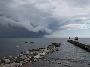 海上から迫るアーチ雲