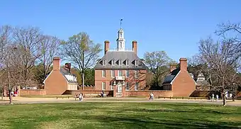 A three story red brick colonial style hall and its left and right wings during winter.