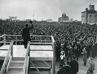 1947年旧広島護国神社境内で行われた昭和天皇全国巡幸の様子。左に鳥居、右に原爆ドーム、右端に旧商工会議所ビルが見える。