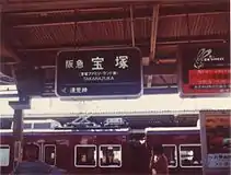 1. 阪急電鉄の駅名標の例（1984年当時の宝塚駅）。1986年までの駅名標は漢字とローマ字の表記しかなかった。