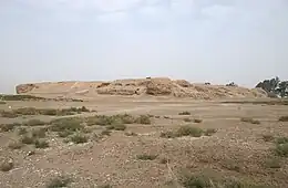 Photo of a mound of ruins in a barren field