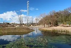 大野極楽寺公園の野鳥の池、右奥に野鳥園、遠景は隣接する国営木曽三川公園地区センターのツインアーチ138（2014年1月10日撮影）