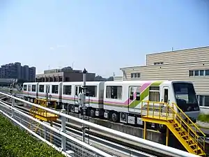 桃花台新交通本社と、停車中の桃花台新交通100系電車