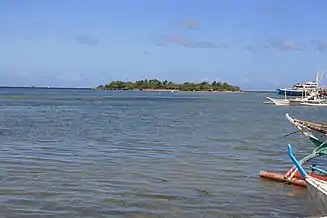  海上の島、600mほど、いくばくかのヤシが生えている。右に4艘の小船（bangkas）が移っている。