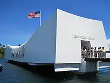 white rectangular memorial building with U.S. flag flying above