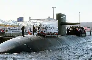 USS Pittsburgh (SSN-720) participates in a dockside ceremony.  Note the USN jack waving from the front of the sub.